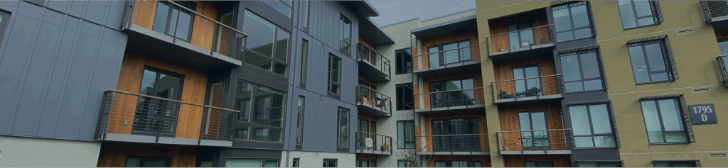 Modern apartment complex featuring Shakertown® natural cedar siding accents, metal panel cladding, and glass balcony railings banner footer